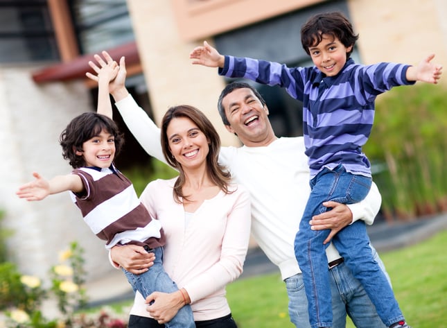 Excited family having fun outdoors with arms up