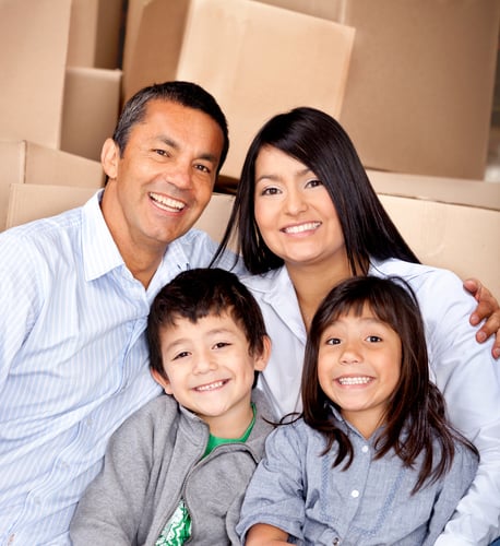 Family moving house with cardboard boxes at the background