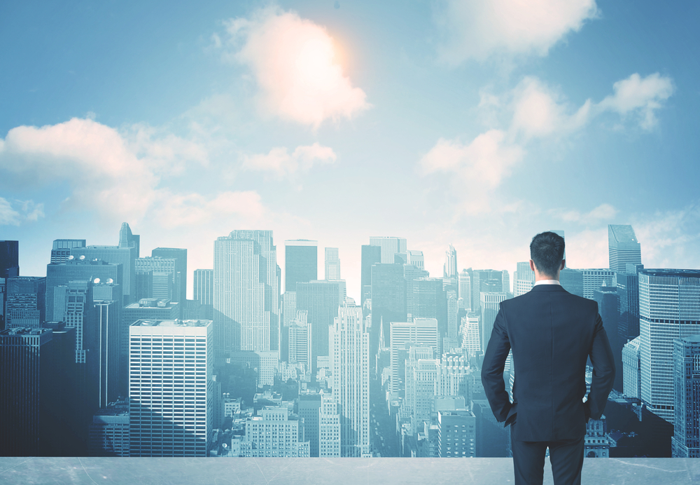 Businessman standing on a roof and looking at future city-2