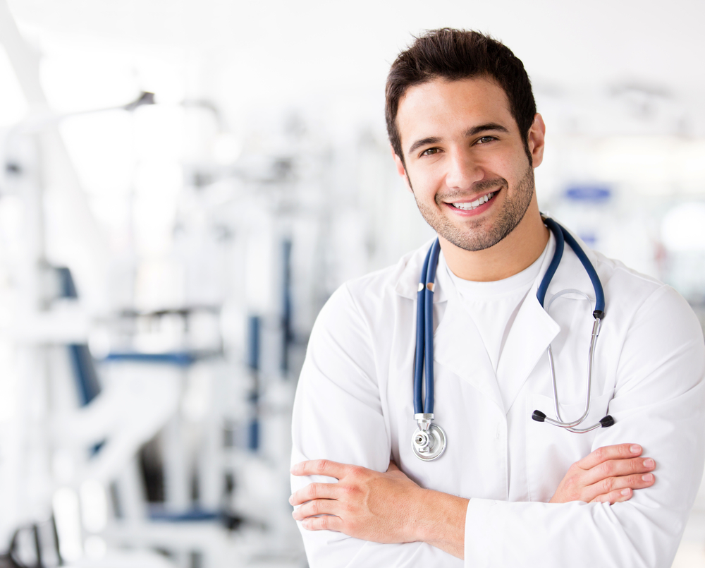 Friendly male doctor at the gym smiling