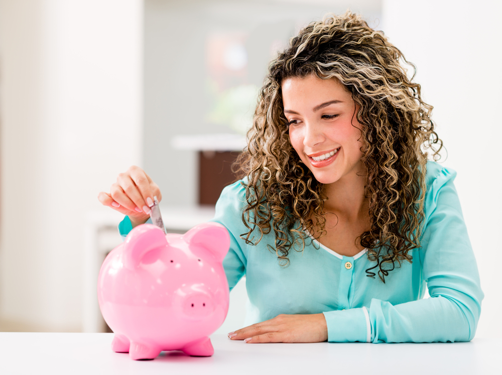 Happy woman saving money in a piggybank-1