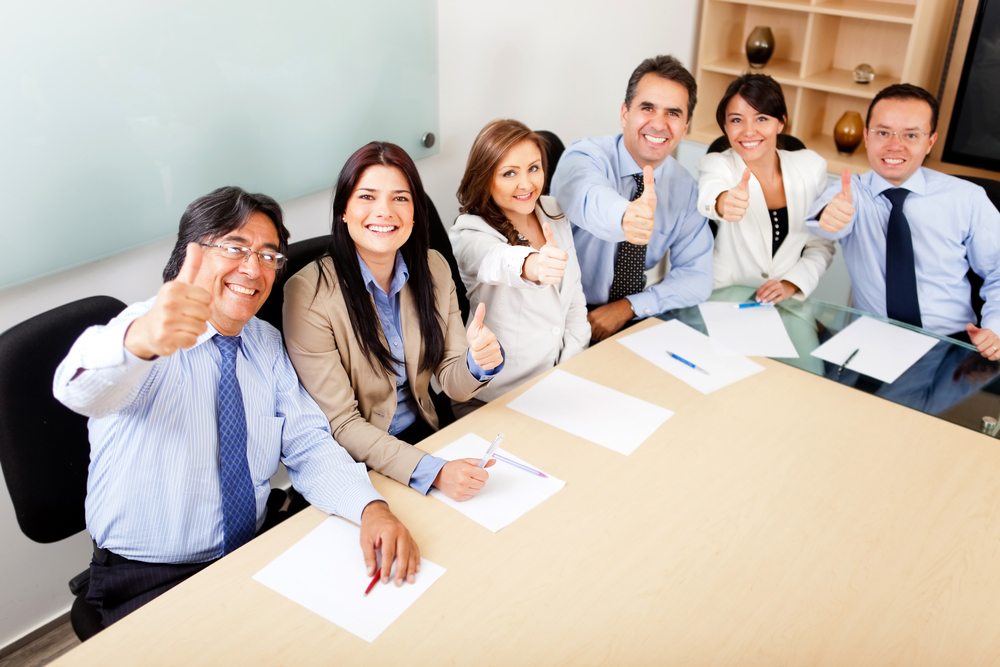 Successful business team in a meeting with thumbs up